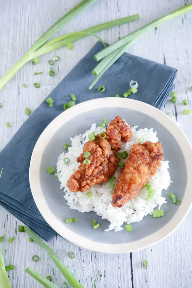 chicken and rice on blue plate with green onions