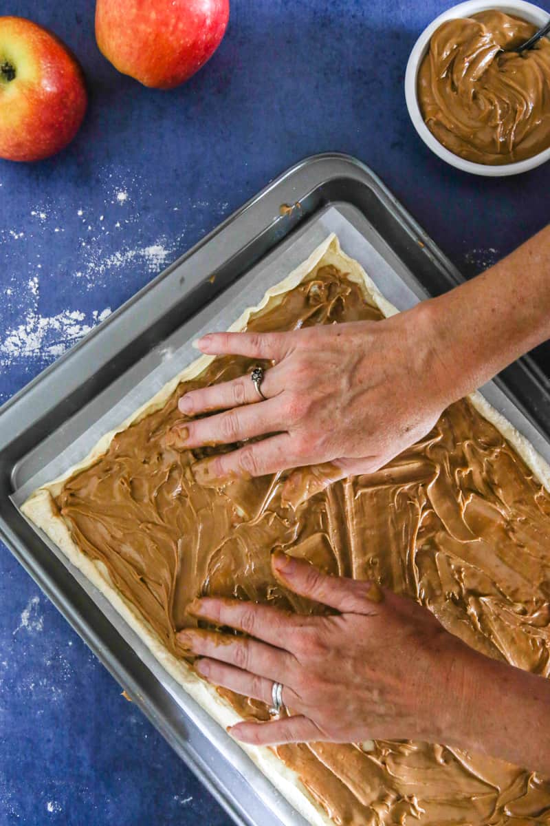 spreading peanut butter on puff pastry